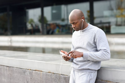 Man using mobile phone while standing in city