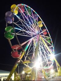 Low angle view of illuminated ferris wheel against sky at night