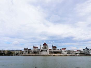 View of buildings in city against cloudy sky