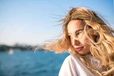 Portrait of a beautiful young woman against sea