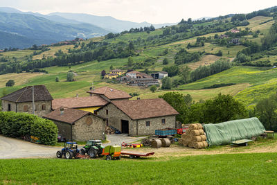 Houses on field by mountains