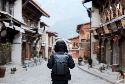 Rear view of woman photographing buildings in city