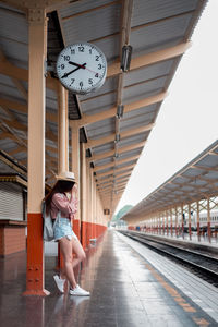 Woman leaning on railroad station platform