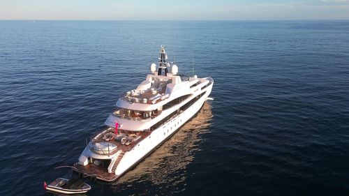 Aerial view of three a superyacht with its tender against blue sky