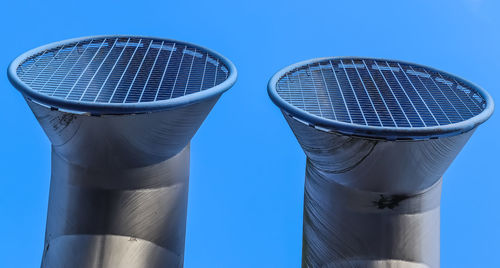 Low angle view of pipe against blue sky