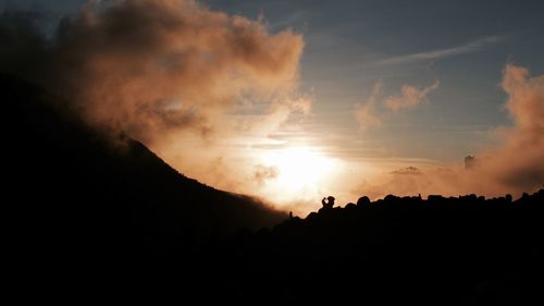 Low angle view of silhouette mountain against dramatic sky