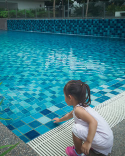 Little asian toddler baby have a fun with a splash near swimming pool