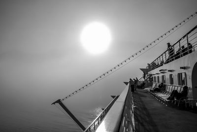 People on ship deck in ocean against sky