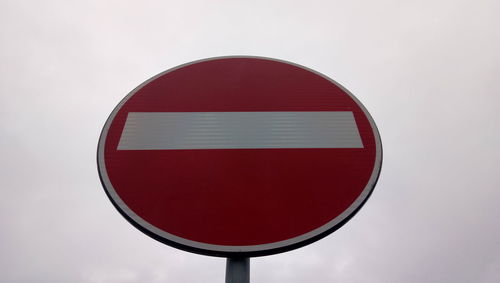 Close-up of road sign against sky