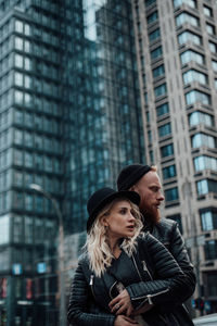 Happy couple standing against office building