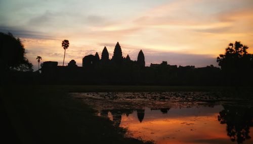 Silhouette of temple building against sky during sunset