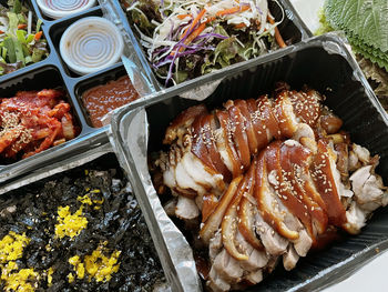 A set of korean jokbal dishes with jumeokbap, makguksu and radish kimchi