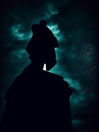 Low angle view of silhouette statue against sky at night