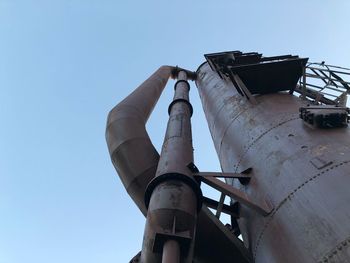 Low angle view of old factory against clear blue sky