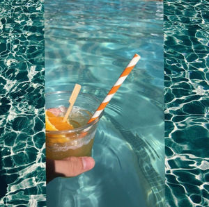 Close-up of hand on glass at swimming pool