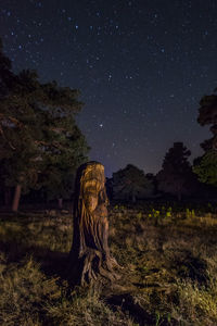 Trees on field against sky at night