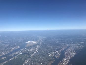 Aerial view of city by sea against clear sky