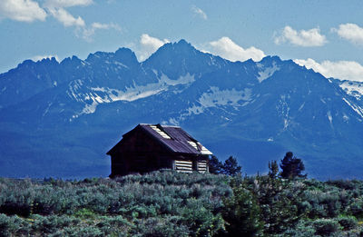 Scenic view of house and mountains against sky