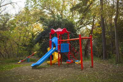 People in playground against trees in park