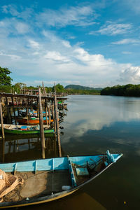 Boats moored in lake against sky