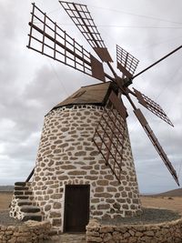 Low angle view of traditional windmill against sky