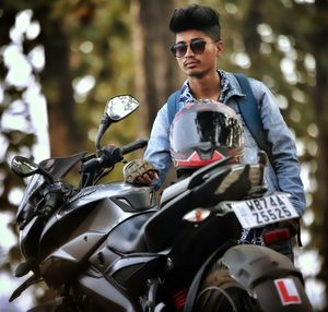 Young man riding sunglasses sitting on motorcycle