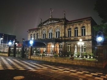 Illuminated building against sky at night