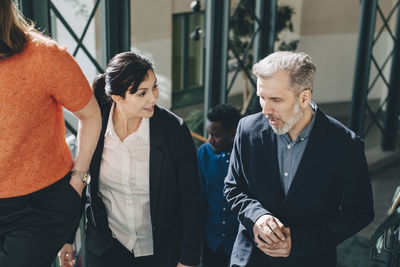 High angle view of business people talking while walking on steps