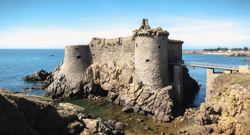 Panoramic view of rocks on beach against sky