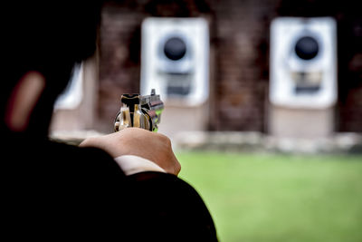 Close-up of man aiming gun during target shooting