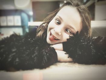 Cute girl making face while lying on table at home