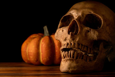 Close-up of pumpkin on table against black background