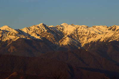Scenic view of snowcapped mountains against clear sky