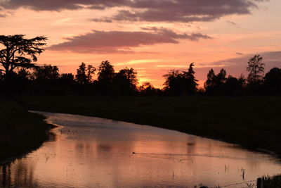 Scenic view of lake against orange sky