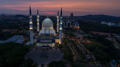 High angle view of city lit up during sunset