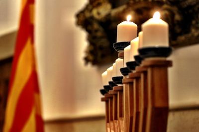 Close-up of illuminated candles on wood at home