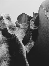 Low angle view of rocks on beach against clear sky