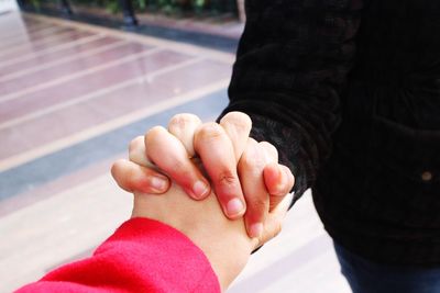 Midsection of couple holding hands