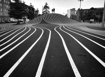 Lines on road amidst buildings