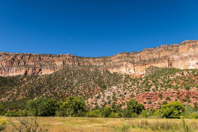 Scenic view of rocky mountains against clear blue sky