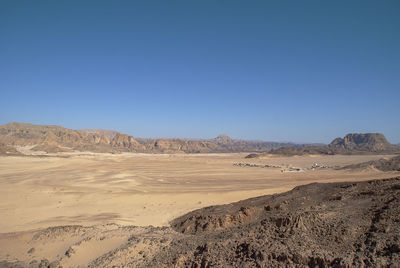 Scenic view of desert against clear blue sky