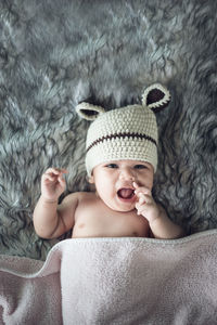 Portrait of cute baby girl lying on bed at home