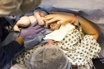 High angle view of mother with newborn baby in hospital