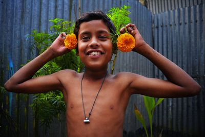 Portrait of shirtless man holding fruits