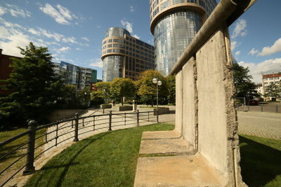 View of footpath by buildings against sky