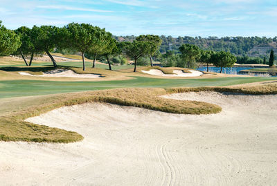 Scenic view of golf course against sky