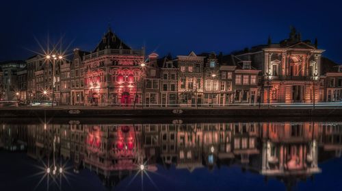 Illuminated buildings in water at night