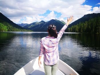 Rear view of woman in lake against mountains
