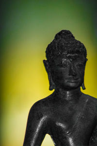 Close-up of buddha statue against wall