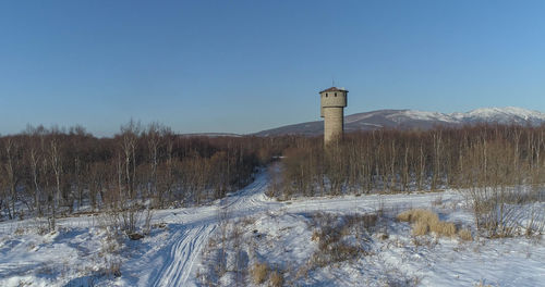 Scenic view of snow covered land against clear blue sky